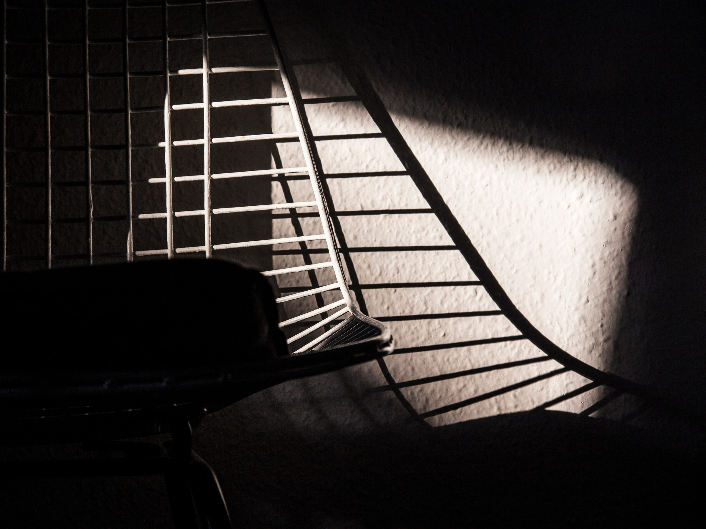 Stuhl im Streiflicht mit Gitterschatten